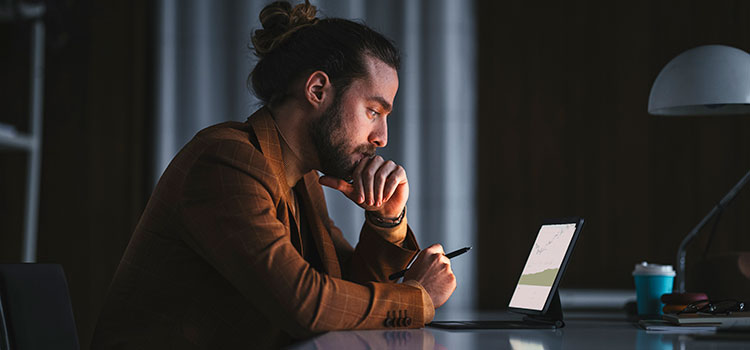 side view of man studying at laptop