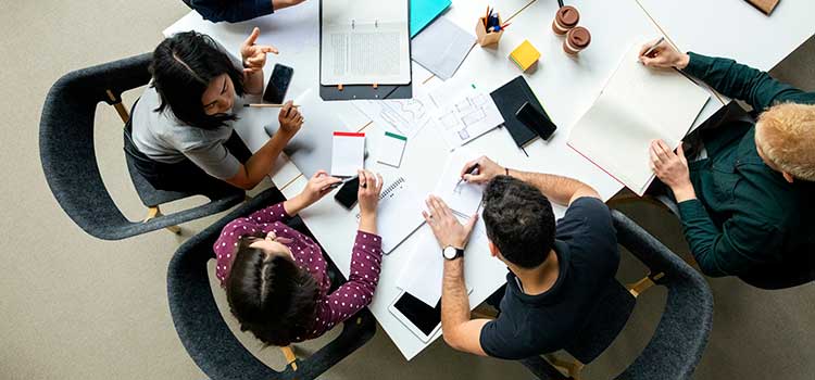 top down view of five people planning project at table