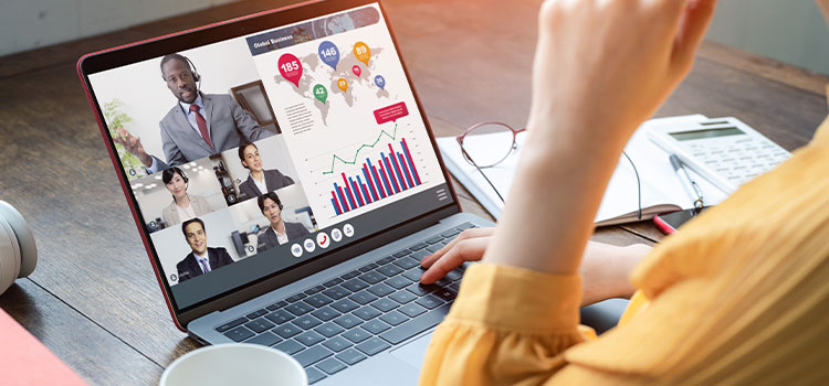 A woman attends an online meeting with colleagues