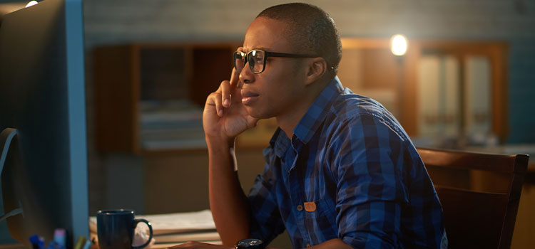 A man takes an exam on his laptop