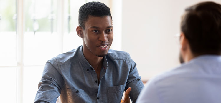 A professional man interviews another man