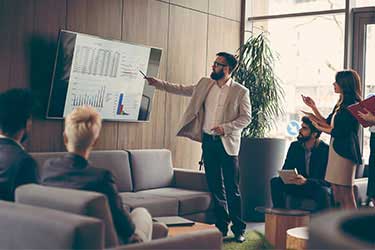 accountant reviews financial data for team on monitor