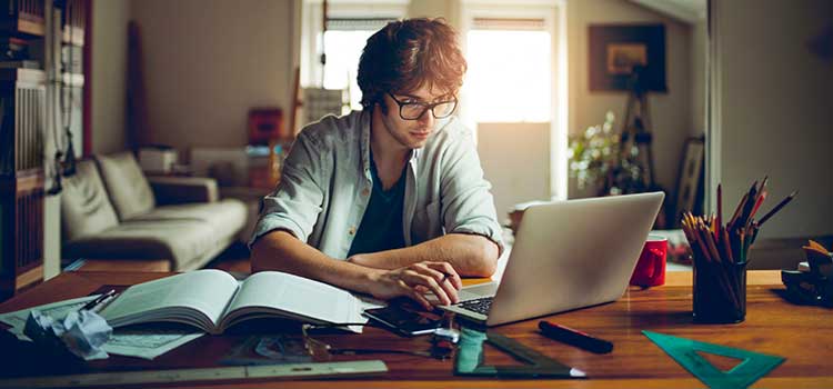 man studying for test at desk at home