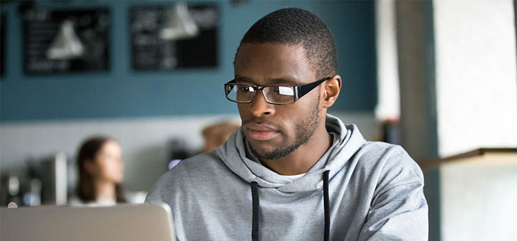 a man reads material on his laptop