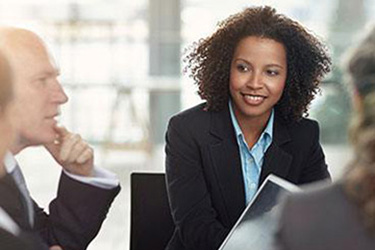 woman sits in meeting with executive team
