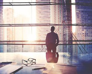 businessman looks out windows in high tech office