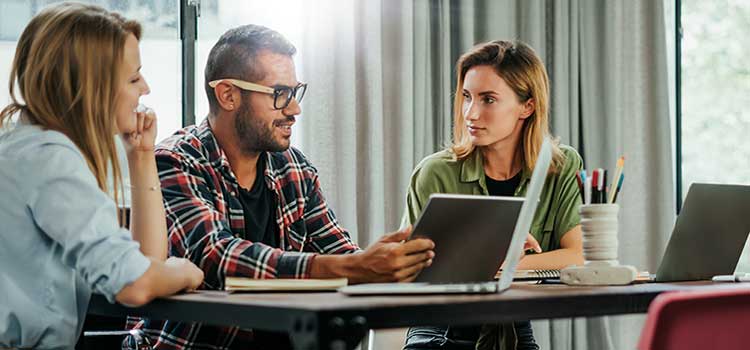 marketing manager shows associates rough campaign outline on tablet