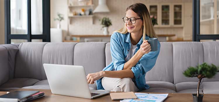 accounting student reviews requirements on laptop at home to take cpa exam